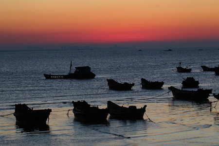 Silhouette of fishing boats during sunsetの写真素材