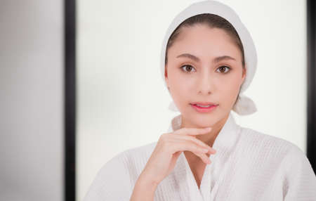 Portrait of beautiful asian woman wearing bathrobe with towel turban in spa salon. Beauty of young female after clean fresh skin care treatment on face and facial treatment with cosmetology in clinic.の写真素材