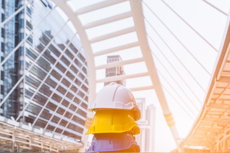 Stack of blue, yellow, white hard safety helmet on concrete floor in construction site. Personal...