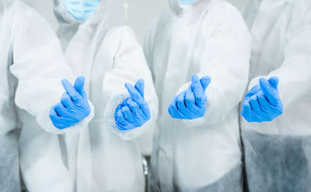 Team of medical scientific researcher standing wearing safety suit and personal protective equipment with make mini heart in lab. Group of scientist test sample of vaccine for protect coronavirus.の写真素材