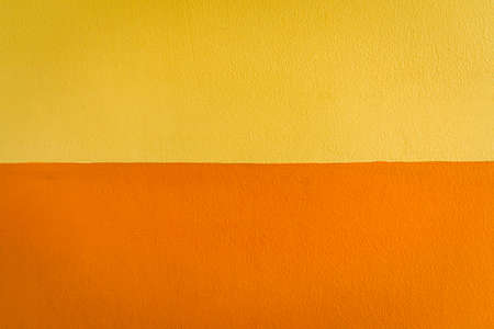 Texture and detail of yellow and orange wall for background.