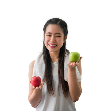 Portrait of happy Asian healthy woman holding green apple at left hand and red apple at right hand isolated on white background with clipping path. Sportsgirl with apple fruit for healthcare concept.の写真素材