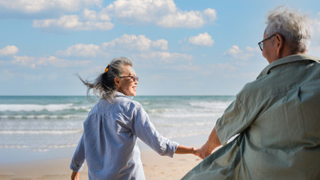 Happy senior woman is enjoying and fun holding hand husband and pull to seaside on beach in vacation...