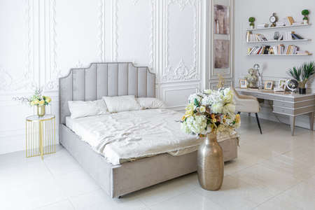 chic luxury interior in an old antique style open-plan apartment decorated with columns and stucco on the wall in pastel colors. tiles on the floor. beige wallsの写真素材