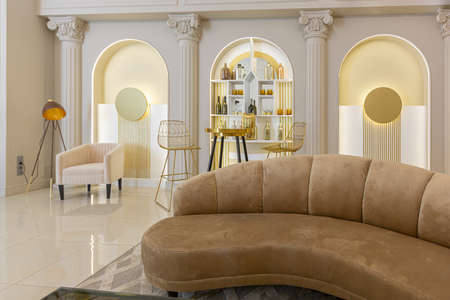 chic luxury interior in an old antique style open-plan apartment decorated with columns and stucco on the wall in pastel colors. tiles on the floor. beige wallsの写真素材