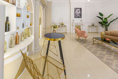 chic luxury interior in an old antique style open-plan apartment decorated with columns and stucco on the wall in pastel colors. tiles on the floor. beige wallsの写真素材