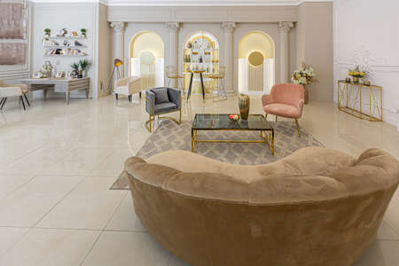 chic luxury interior in an old antique style open-plan apartment decorated with columns and stucco on the wall in pastel colors. tiles on the floor. beige wallsの写真素材