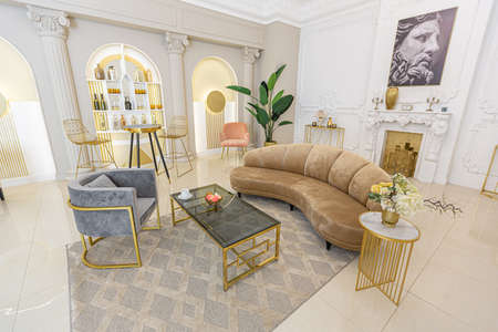 chic luxury interior in an old antique style open-plan apartment decorated with columns and stucco on the wall in pastel colors. tiles on the floor. beige wallsの写真素材