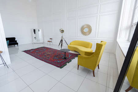 modern fashionable futuristic interior design of a spacious white hall with black and yellow furnitureの写真素材