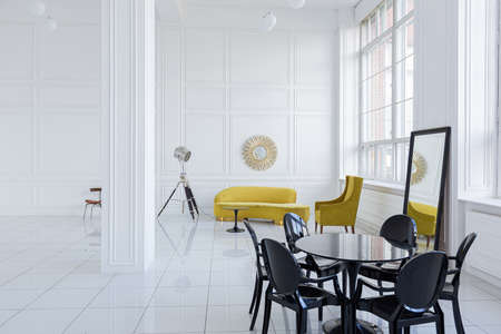 modern fashionable futuristic interior design of a spacious white hall with black and yellow furnitureの写真素材