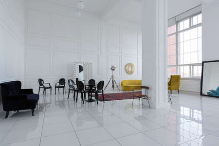 modern fashionable futuristic interior design of a spacious white hall with black and yellow furnitureの写真素材