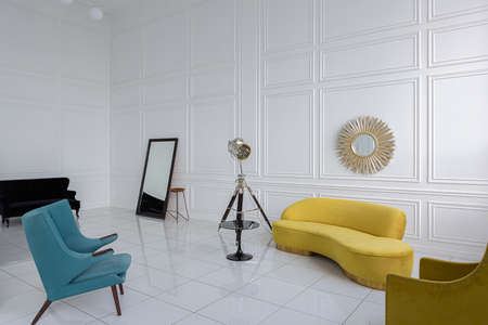 modern fashionable futuristic interior design of a spacious white hall with black and yellow furnitureの写真素材