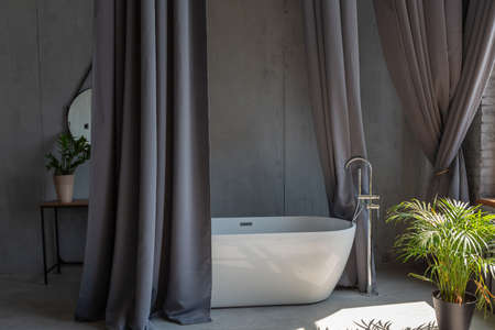 Modern minimalistic dark gray loft style studio apartment interior design. kitchen, sitting area, workplace, shower and bath. bright sun rays inside.の写真素材