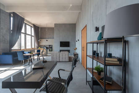 Modern minimalistic dark gray loft style studio apartment interior design. kitchen, sitting area, workplace, shower and bath. bright sun rays inside.の写真素材
