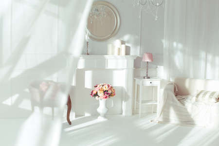 luxury clean bright white interior. a spacious room with sunlight and flowers in vasesの写真素材