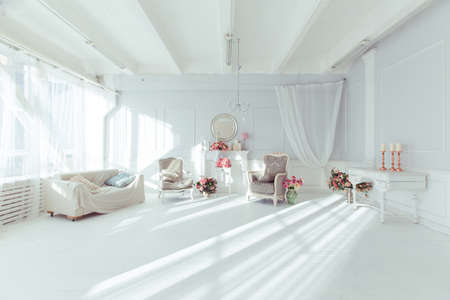 luxury clean bright white interior. a spacious room with sunlight and flowers in vasesの写真素材