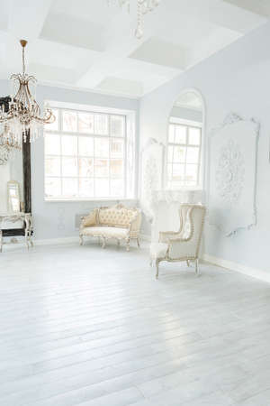 Luxury rich living room interior design with elegant classic furniture and wall decorations. Large light white room with big windowの写真素材