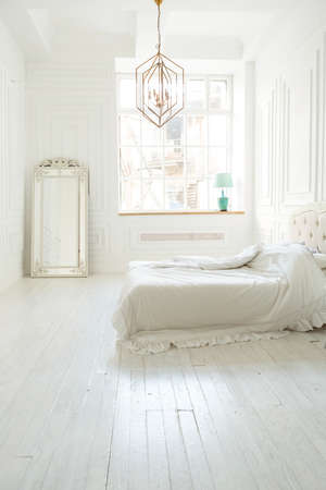 Stylish luxury white bedroom interior design in soft day light with elegant classic furnitureの写真素材