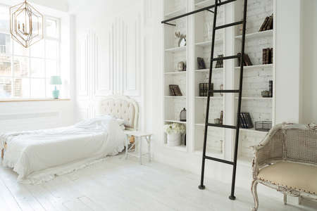 Stylish luxury white bedroom interior design in soft day light with elegant classic furnitureの写真素材
