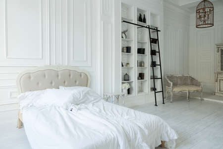 Stylish luxury white bedroom interior design in soft day light with elegant classic furnitureの写真素材