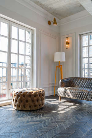 Chic, luxurious guest room design with old-fashioned antique furniture. white walls are decorated with relief. there is a beautiful dark brown parquet on the floor.の写真素材