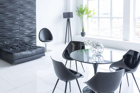 Luxurious futuristic trendy modern interior in contrasting black and white colors with interesting fashionable black furniture and decorated wallの写真素材