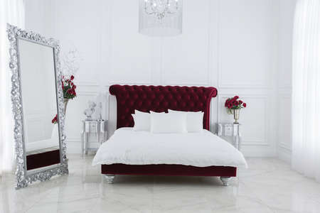 Luxury white light bedroom interior design. Dark red large bed