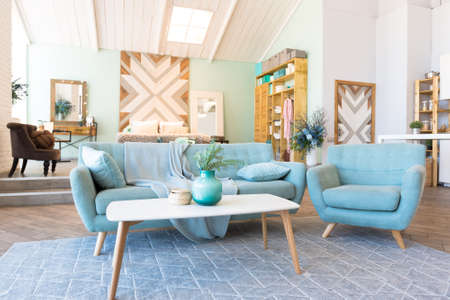 Fashionable spacious apartment with a stylish design in green, gray and white pastel colors with big window and decorative walls. bedroom and kitchen spaceの写真素材