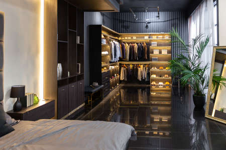 dark modern stylish male apartment interior with lighting, decorative walls, fireplace, dressing area and huge windowの写真素材