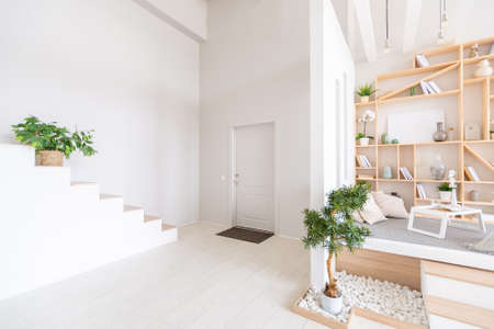 Luxury fashionable modern design studio apartment with a free layout in a minimal style. very bright huge spacious room with white walls and wooden elements.の写真素材