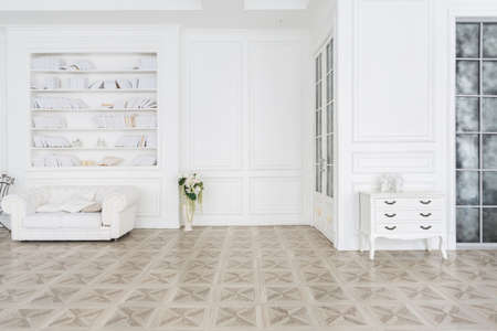 Luxury white interior of living spacious room with elegant chic furniture and high windows.の写真素材