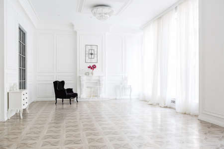 Luxury white interior of living spacious room with elegant chic furniture and high windows.の写真素材