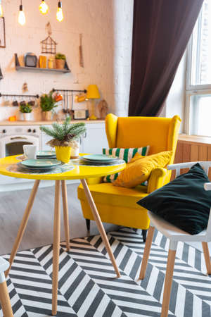 Trendy fashion luxury interior design in Scandinavian style of studio apartment with bright yellow furniture and decorated with new year lights.の写真素材