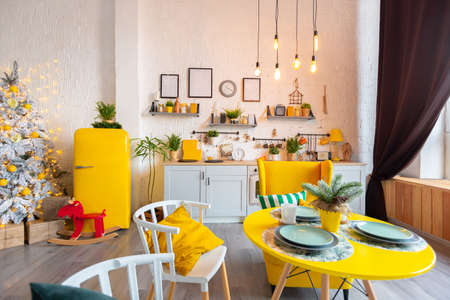 Trendy fashion luxury interior design in Scandinavian style of studio apartment with bright yellow furniture and decorated with new year lights.の写真素材