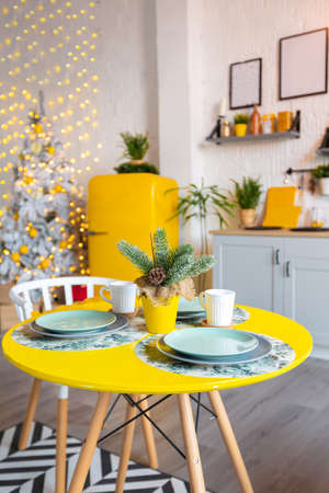 Trendy fashion luxury interior design in Scandinavian style of studio apartment with bright yellow furniture and decorated with new year lights.の写真素材