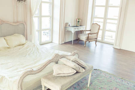 beautiful white bright clean interior bedroom in luxurious baroque style.