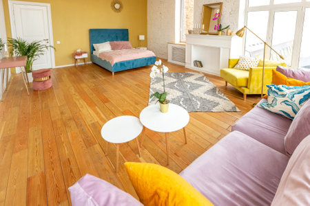 Scandinavian style apartment interior. bright yellow warm colors. wooden flooring. sunlight in large windows.の写真素材