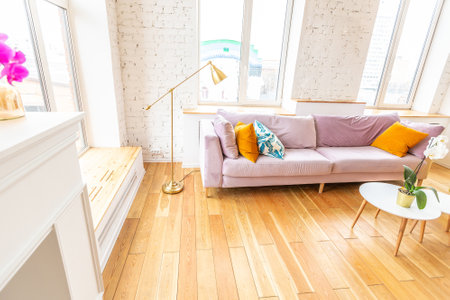 Scandinavian style apartment interior. bright yellow warm colors. wooden flooring. sunlight in large windows.の写真素材