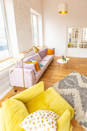 Scandinavian style apartment interior. bright yellow warm colors. wooden flooring. sunlight in large windows.の写真素材