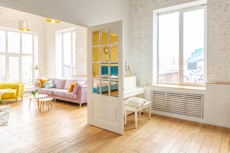 very light and sparcious two-rooms apartment in scandinavian design style with fashion furniture and large windows. warm colors during day timeの写真素材