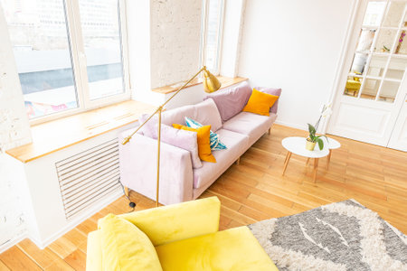 Scandinavian style apartment interior. bright yellow warm colors. wooden flooring. sunlight in large windows.の写真素材