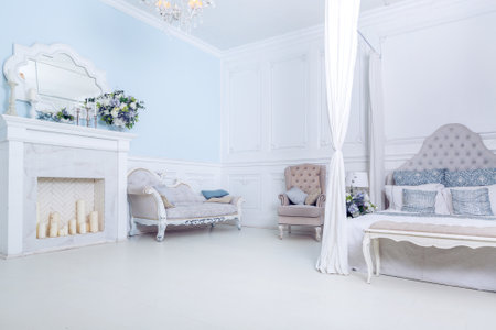 bright, clean stylish interior bedroom and living room with a large panoramic window. beautiful rich antique furniture. four-poster bed, a mirror and a sofa.の写真素材