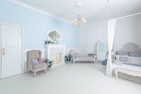 bright, clean stylish interior bedroom and living room with a large panoramic window. beautiful rich antique furniture. four-poster bed, a mirror and a sofa.の写真素材