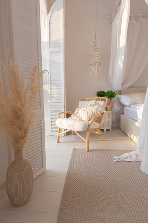 Cozy interior of a bright Balinese-style apartment with white walls, bamboo furniture. bed room with...