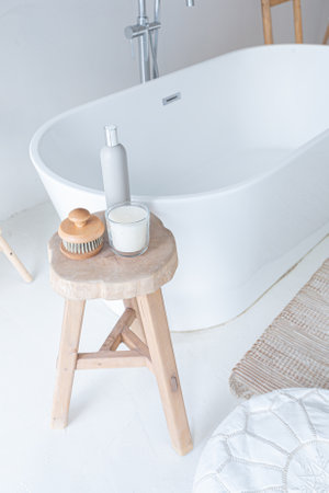 Extra white and very light minimalistic stylish elegant interior of bathroom with modern bath, green...