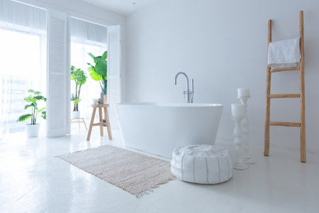 Extra white and very light minimalistic stylish elegant interior of bathroom with modern bath, green plants and wooden elementsの写真素材