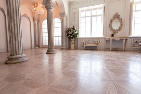 Luxurious light interior of the living room in the baroque style as in a royal castle with old stylish vintage furniture, columns, stucco on the wallsの写真素材