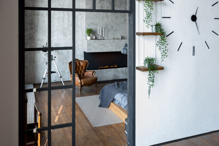 luxury studio apartment with a free layout in a loft style in dark colors. Stylish modern kitchen area with an island, cozy bedroom area with fireplace and personal gymの写真素材