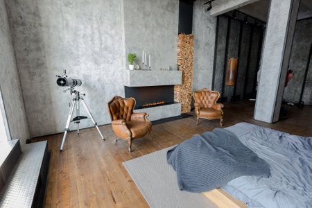 luxury studio apartment with a free layout in a loft style in dark colors. Stylish modern kitchen area with an island, cozy bedroom area with fireplace and personal gymの写真素材