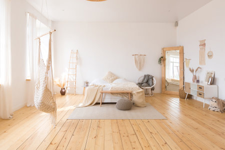 cute cozy light interior design of the apartment with a free layout of the kitchen and bedroom areas. a lot of windows, a wooden floor and a hanging swing.の写真素材